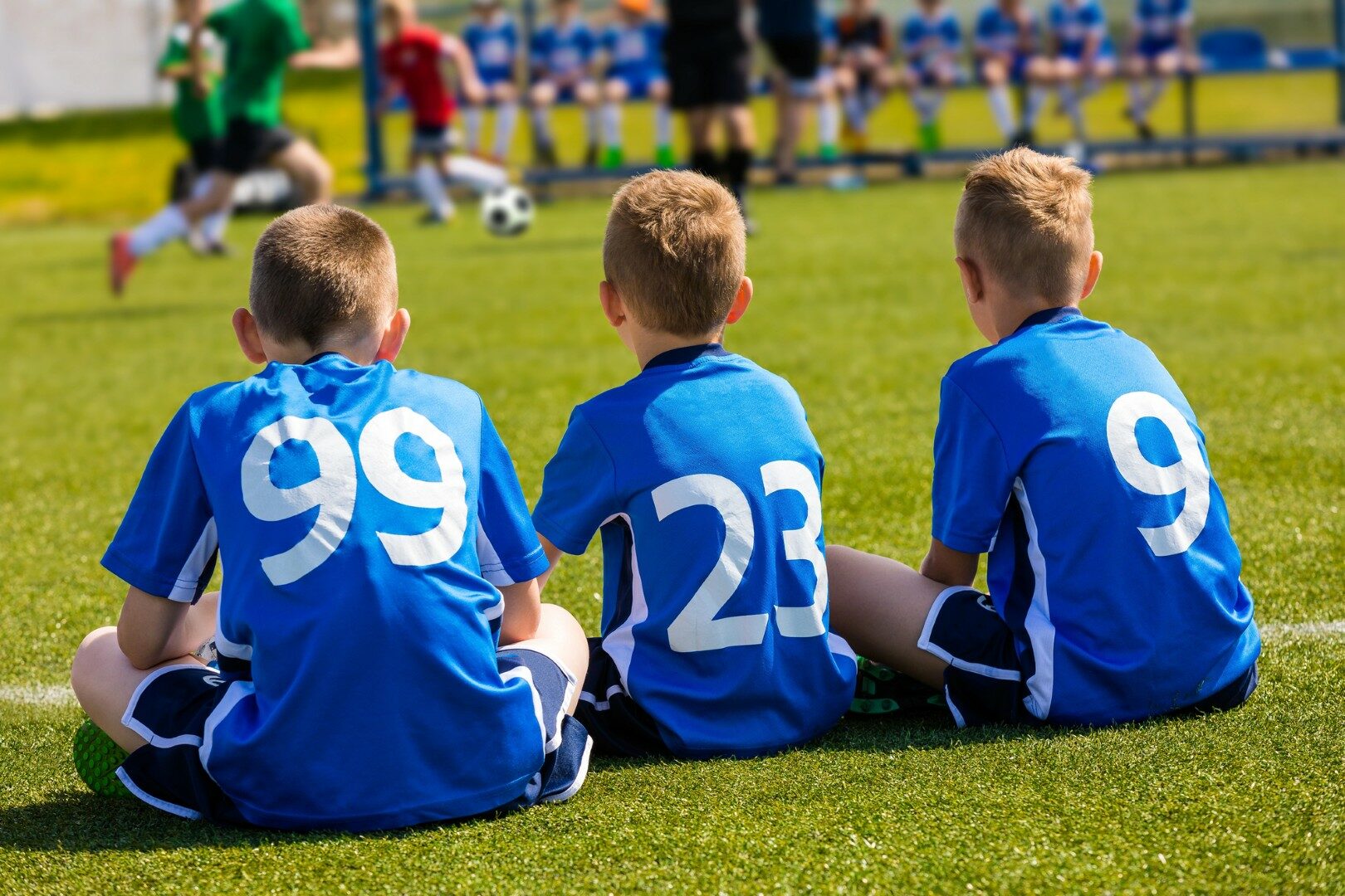 Kinderen voetbalteam kijken naar voetbalwedstrijd
